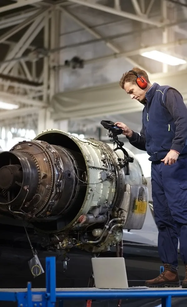A Man Repairing a Jet Engine